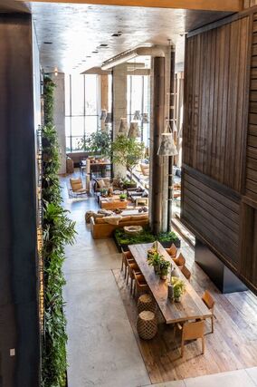 Overview of the mixed seating layout and use of wood plants and concrete in the lobby at Hotel Brooklyn New York