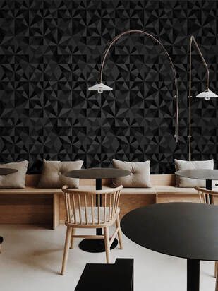 Jewel Onyx geometric patterned wallpaper in shades of black on a wall in a cafe interior