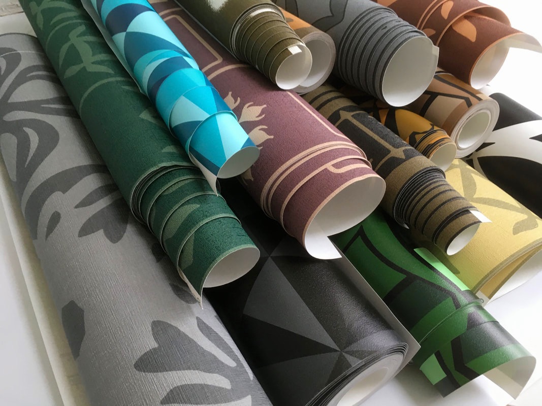 Rolls of Luke Edwards Interior Design wallpaper stacked on top of each other