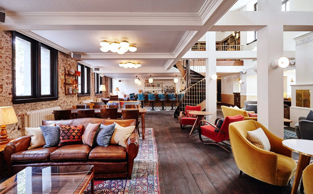 Industrial style interior with rugs and various seating layouts in the Hoxton Hotel Amsterdam