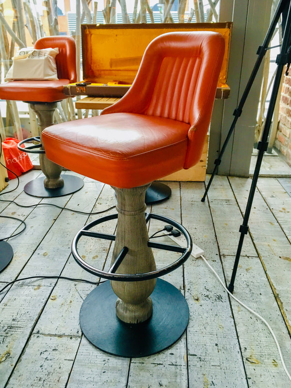 Orange leather upholstered wooden bar stool with iron footrest