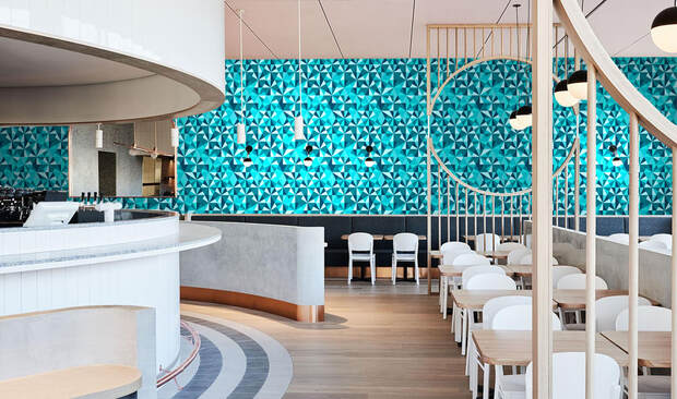 Blue toned Jewel Ocean geometric patterned wallpaper on a wall in an airport lounge interior