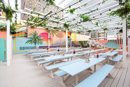 Colourful wall graphics and bench seating in this outdoor roof terrace bar at Pergola Paddington