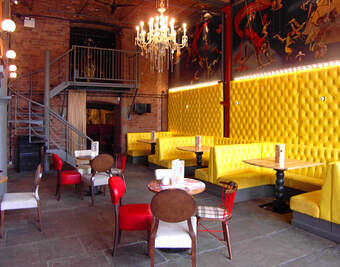 Yellow upholstery with wall graphics above in this cafe bar interior design project in Liverpool